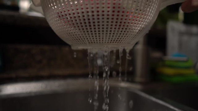 Water dropping from a strainer from washing strawberries. Shot on Batis 25mm on a Sony A7iii.