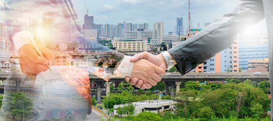 ‪Double Exposure concept. Business man signing and Shake hands.