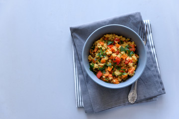 Healthy vegan bowl with quinoa, pumpkin, pepper and carrot on gray wooden background. Selective focus