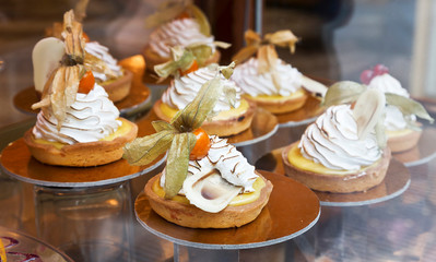 cakes in raspberries and physalis in the window of a pastry shop