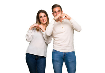 Fototapeta premium Couple in valentine day making heart symbol by hands