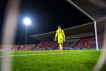 Football game, keeper, goal net and game in the night at the stadium