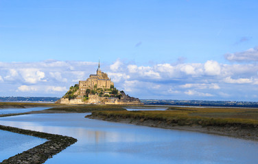 Fototapeta na wymiar the mont saint-michel with the blue sea in the foreground in summer