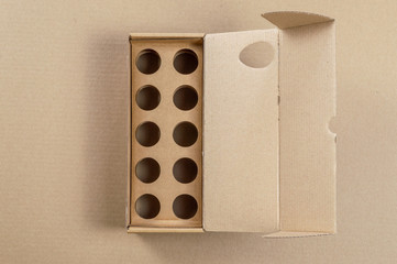 Top view of cardboard egg container on a brown background