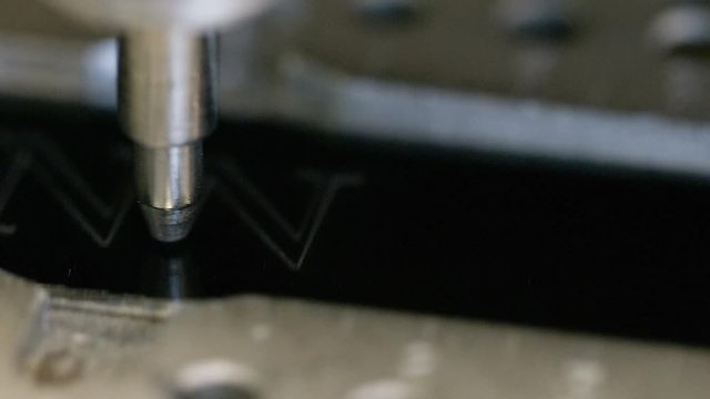 CNC engraving machine etching the word WINNER on a metallic surface