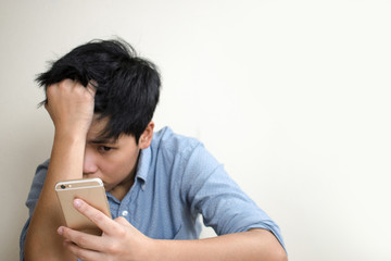 The only sad man is checking the mobile phone sitting on the floor in the room.