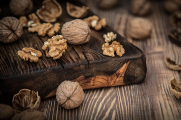 Close up view composition of walnut kernels and whole walnuts on rustic cuting desk. Selective focus 4