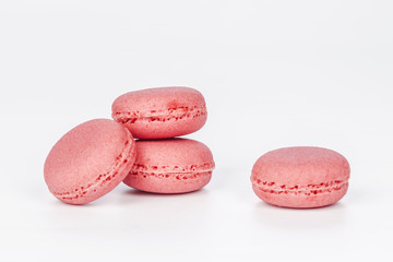 Delicious four pink macarons or macaroons isolated on a white background