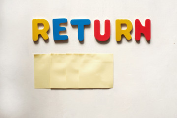 the word of RETURN by colored letters on white wooden background