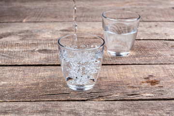Glasses of water on a wooden table.