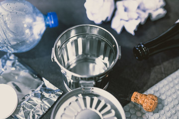 open empty garbage bin surrounded by reusable waste materials like plastic paper and glass