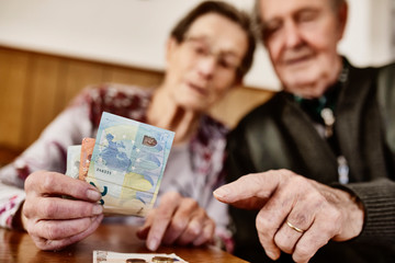 Senior, Seniorin, Seniorenpaar zählt liebevoll ihr gemeinsames Geld
