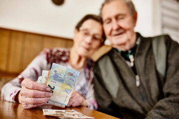Senior, Seniorin, Seniorenpaar zählt liebevoll ihr gemeinsames Geld
