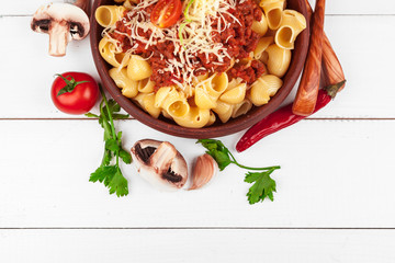 Pasta with meat, tomato sauce and vegetables on the table