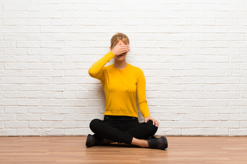 Young girl sitting on the floor covering eyes by hands. Do not want to see something