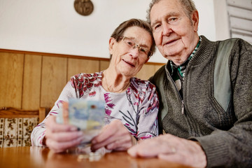 Senior, Seniorin, Seniorenpaar zählt liebevoll ihr gemeinsames Geld