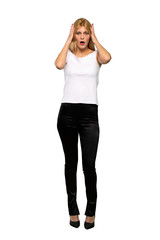 Fototapeta premium Young blonde woman surprised and shocked while looking right over isolated white background