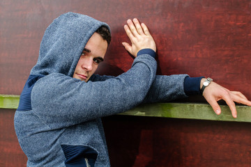 young guy posing funny on a background of a wall