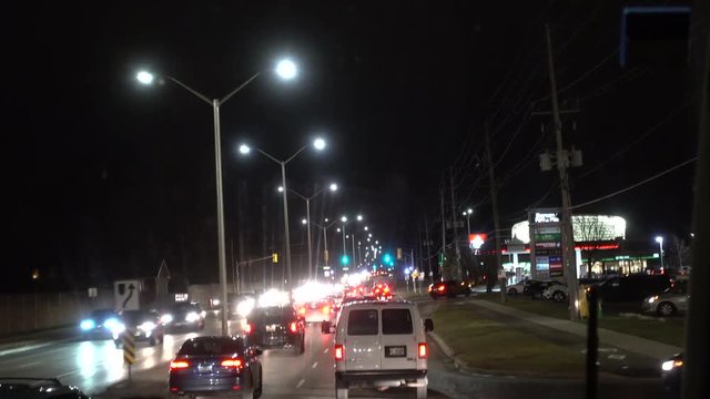 4K City Traffic At Night On Road With Shopping Complex And Aquatic Centre On Right Side