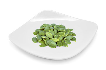 pumpkin seeds on plate isolate on white background