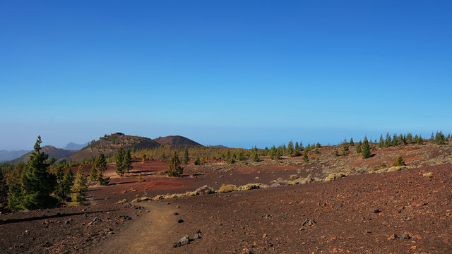 Path through the lunar landscape of Montana Samara in Teide National Park, one of the most alien-like, volcanic land in Tenerife with views towards Pico del Teide, Pico Viejo, and Las Cuevas Negras