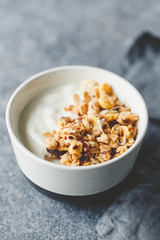 Breakfast bowl with organic granola, nuts, coconut chips and greek yoghurt.