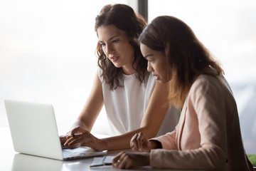 Serious diverse african and caucasian businesswomen workers talk discuss online project work...