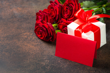 Holiday background with card, present and flowers.