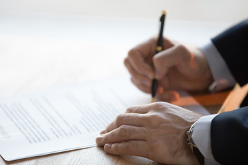 Close up view of male hand signing commercial financial contract concept, businessman put written...