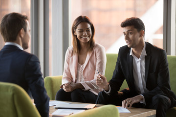 Arabic businessman discussing deal or offer talking to caucasian partner at meeting, diverse...
