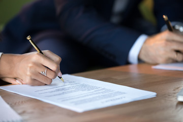 Close up view of woman and man signing document concluding contract concept making prenuptial...
