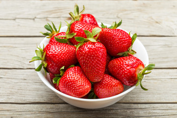 Fresh ripe strawberries in a simple white bowl