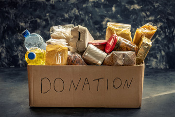 Donation box full of different products on dark background