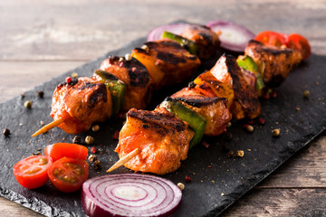 Chicken shish kebab with vegetables on wooden table