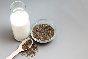 Chia seeds in wooden spoon on grey background.copy spase.Chia seeds in wooden spoon, lying on dark stone background