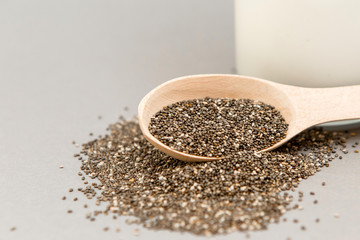 Chia seeds in wooden spoon on grey background.copy spase.Chia seeds in wooden spoon, lying on dark stone background