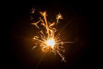 Christmas sparkler or firework on light bokeh background