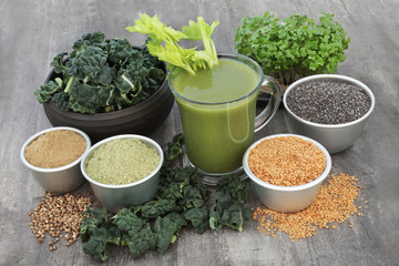 Fresh smoothie juice health drink with kale, mustard and cress, matcha and hemp powder, flax and chia seed on rustic wood background. High in omega 3, antioxidants, vitamins and dietary fibre.