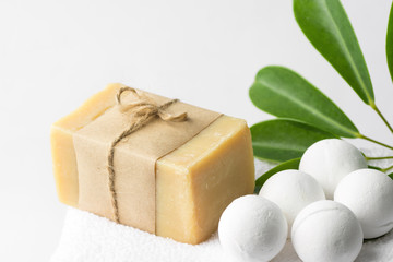 Handmade salt bath bombs in balls shape from organic vegan natural ingredients hand crafted Marseille soap on white towel green house plants. Spa wellness body care wellbeing. Clean minimalist style