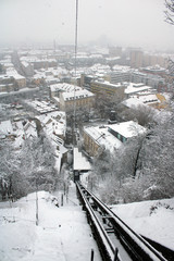 Naklejka premium Binario e cavo funicolare con nevicata urbana