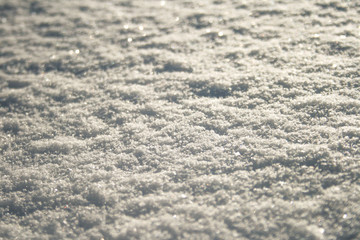 Snow surface close up, winter background with snowflakes at sunset