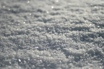 Obraz premium Snow surface close up, winter background with snowflakes at sunset