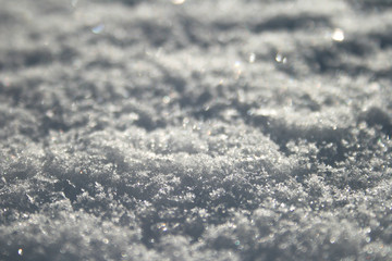 Fototapeta na wymiar Snow surface close up, winter background with snowflakes at sunset
