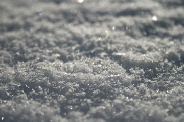 Obraz premium Snow surface close up, winter background with snowflakes at sunset