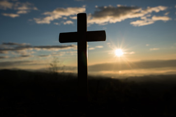 Silhouette of catholic cross and sunrise