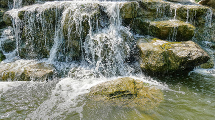 Fototapeta na wymiar Tranquil Background of Waterfall and Small Rocks
