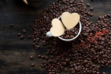 Coffee's bean in white cup of coffee and wooden cartoon heart in cup. prepare to grind and brew hot coffee.