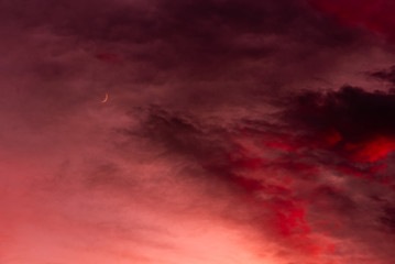 Sunset over forest with dramatic sky with moon
