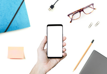 Phone in the hand with desk background