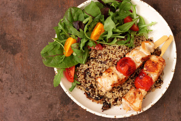 Healthy dinner.Grilled chicken and quinoa, mix salad and tomato 